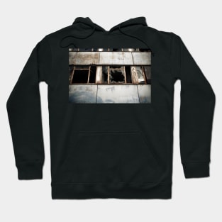 Broken windows of a derelict modern building in East Berlin. Hoodie